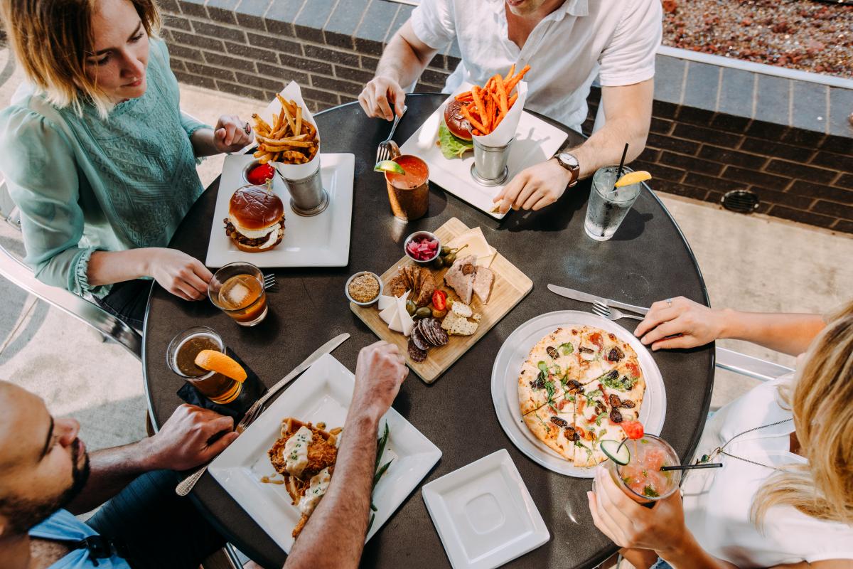 a group of people sitting around a table eating food.
