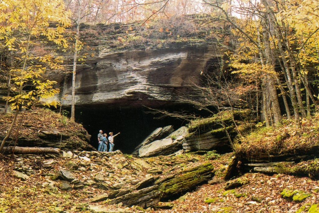 two people standing in front of a cave.