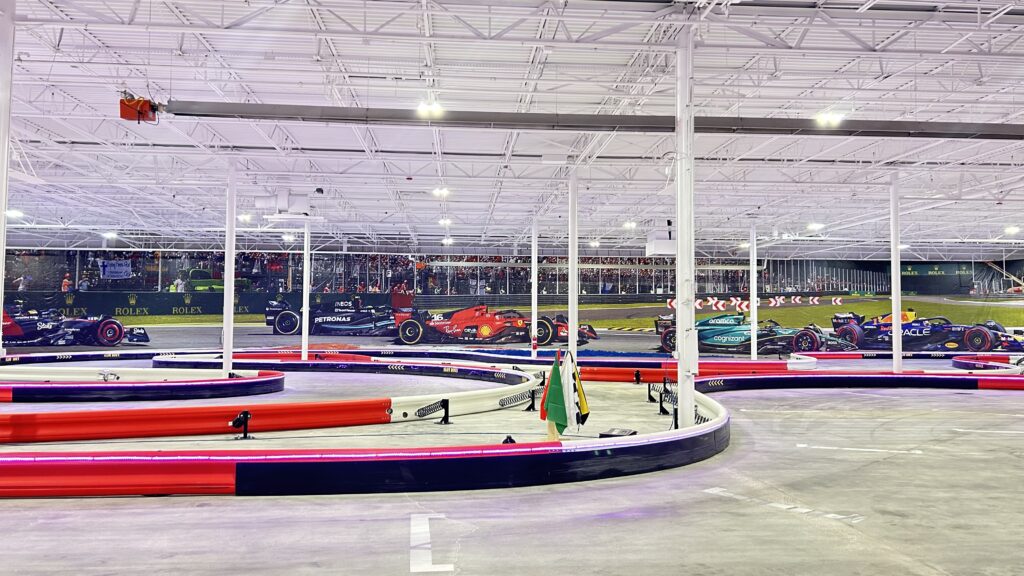 A large indoor race track with many cars in it.