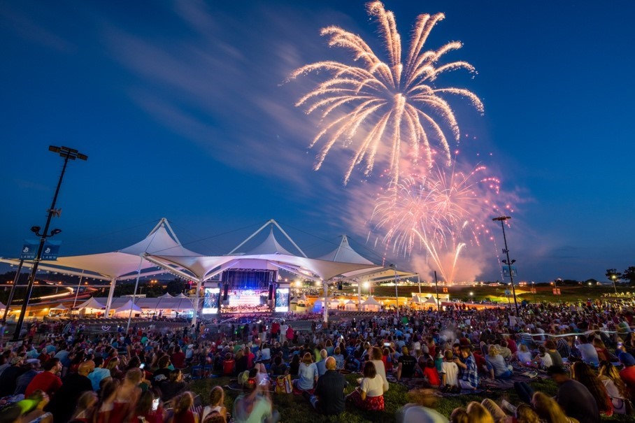 A crowd of people watching fireworks at a concert.