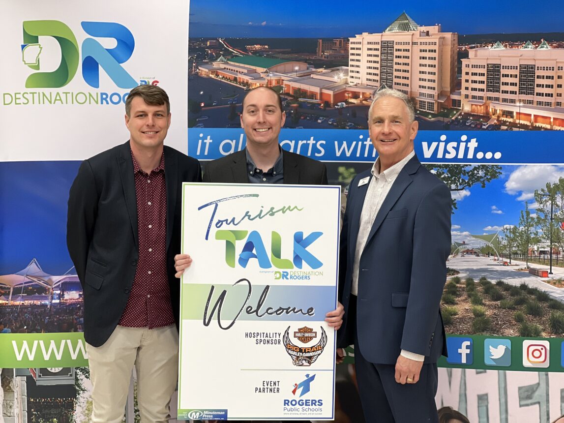 Three men standing in front of a sign that says dr talk.