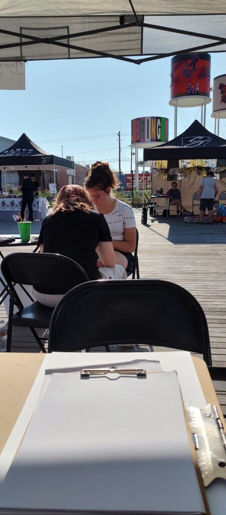 A group of people sitting at a table under a tent.