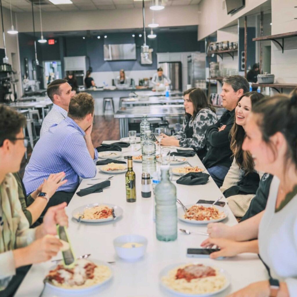 A group of people sitting around a table eating pizza.