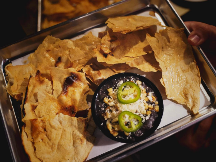 a tray of nachos from Local entrepreneur collaborates with local artist to bring artisanal food, beverages, and art to Downtown Rogers at Yeyo’s Mezcaleria y Taqueria.