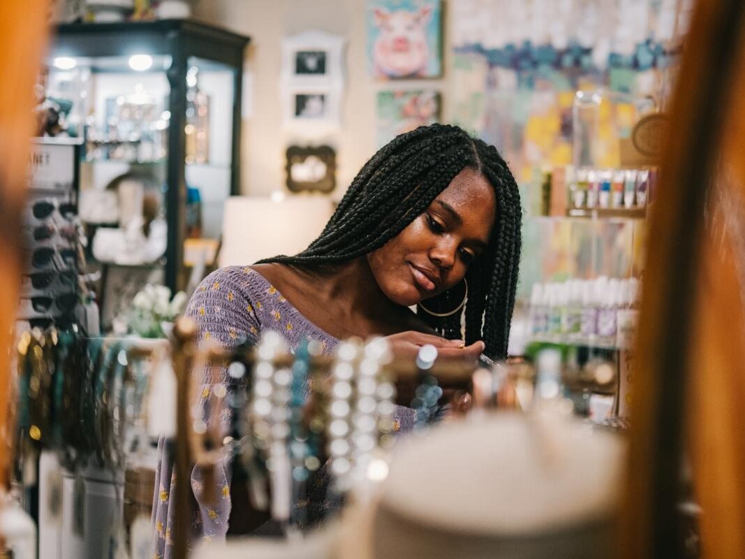 a woman looking at jewelry in a store.