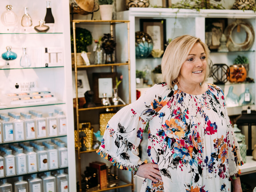 a woman in a floral dress standing in a store.