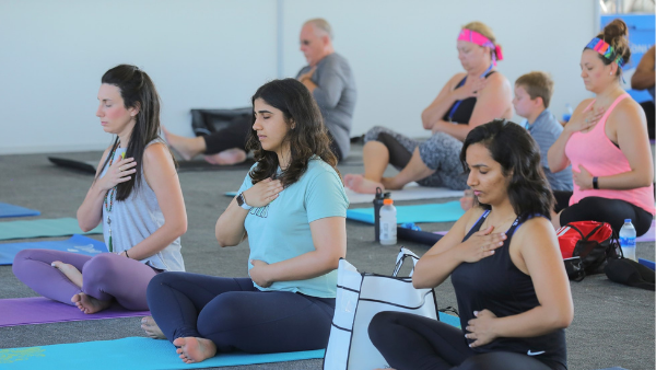 a group of people doing yoga in a gym.