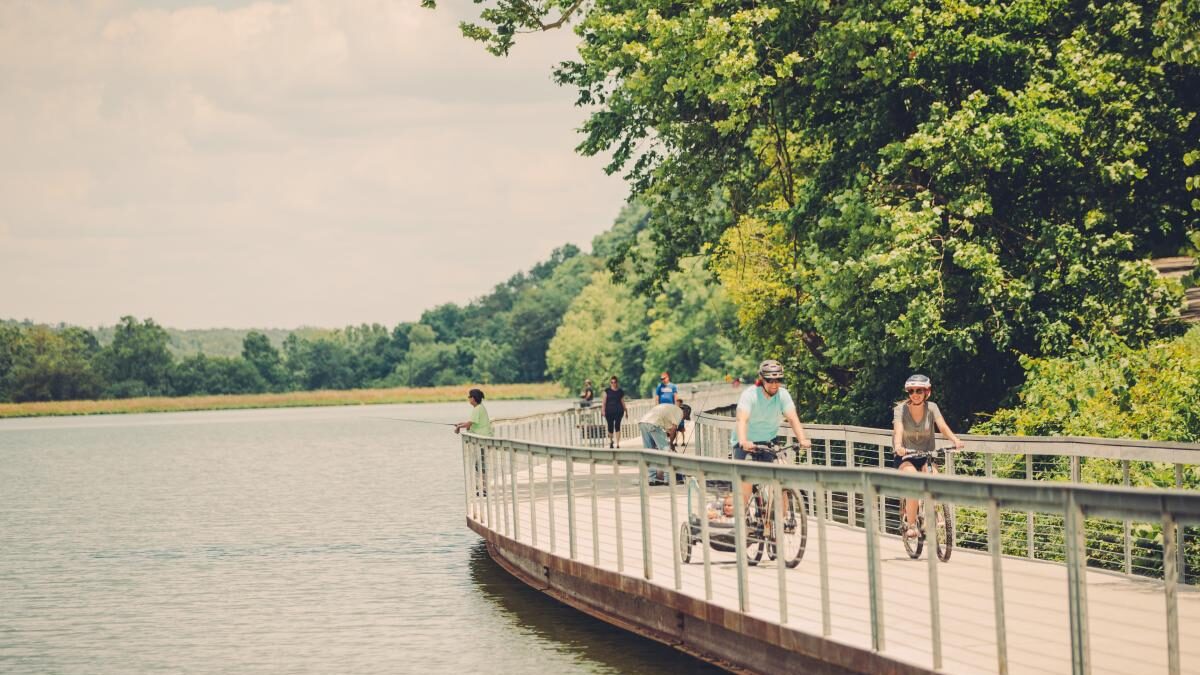 a group of people riding bikes in lake atalanta ar park