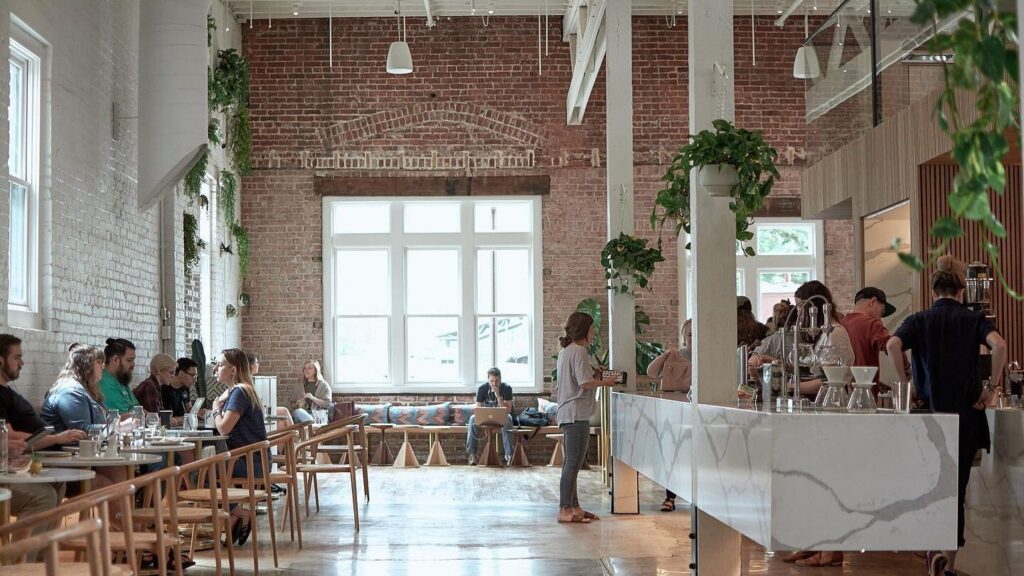 the interior of a restaurant with tables and chairs.