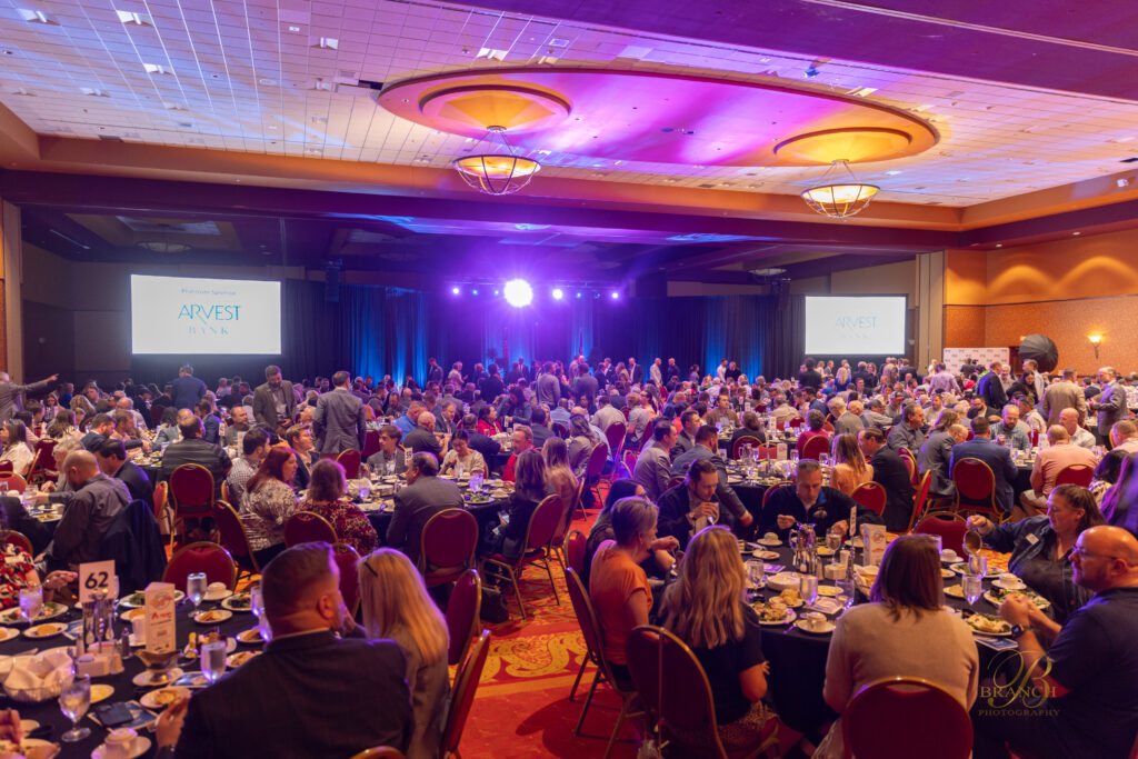 People eating in Rogers Convention Center at banquet tables