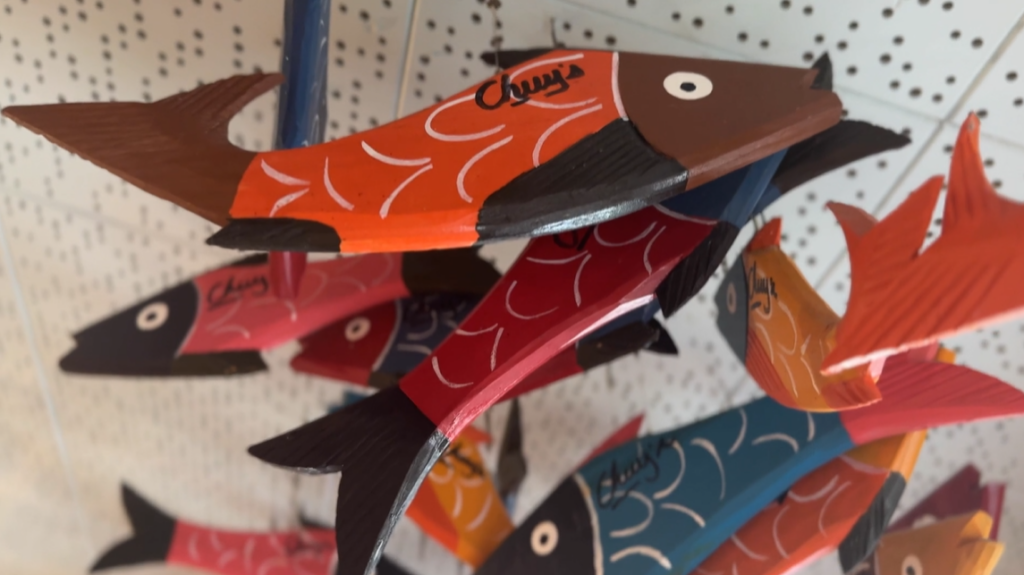 A group of colorful wooden fish decorations hangs from the ceiling, each painted with patterns and the word "Chuy's" on the side.