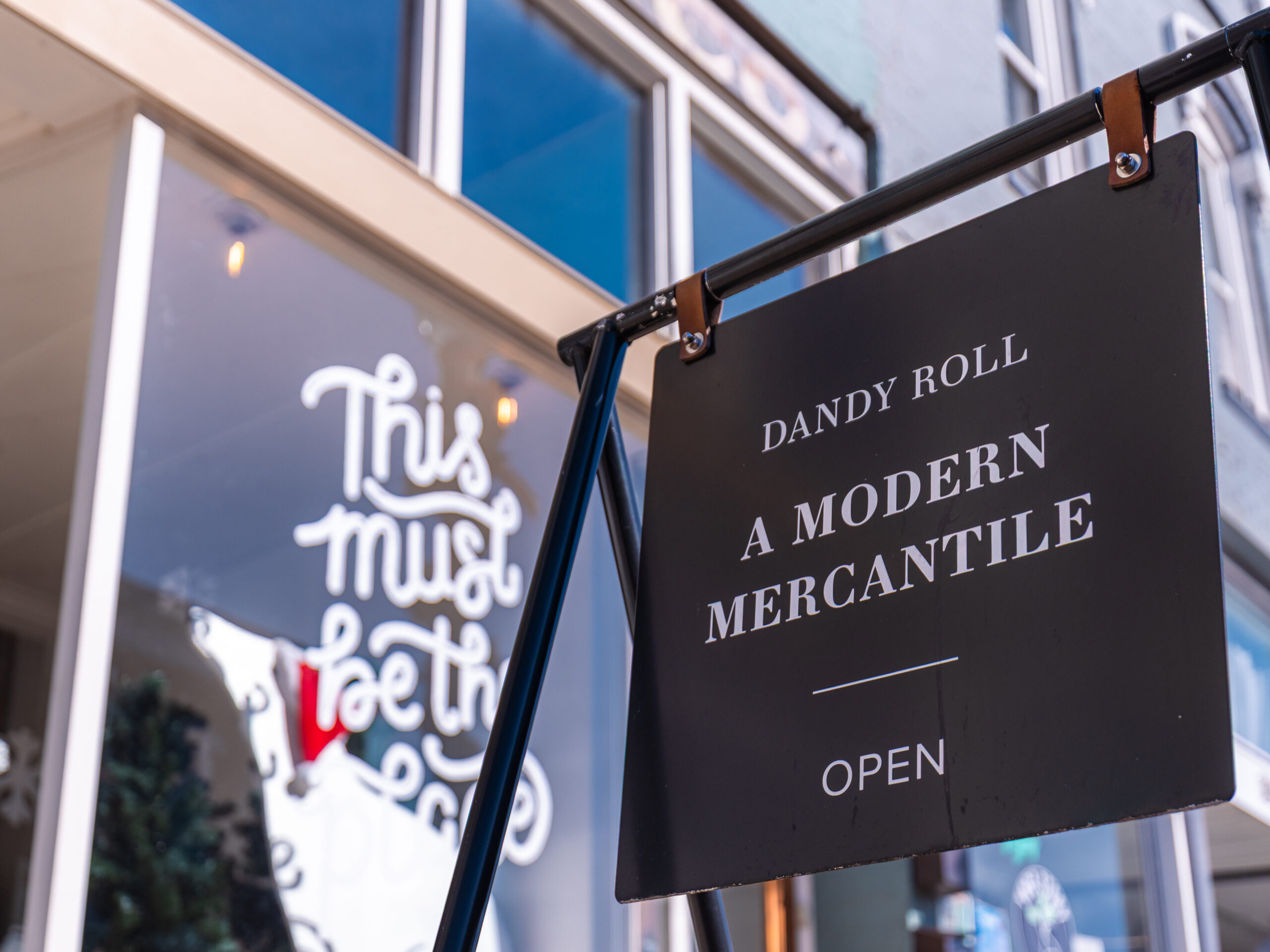 A sign on a stand outside a store.